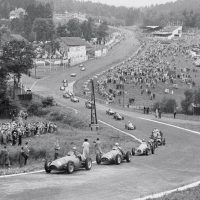 Belgian GP Spa June 22, 1952 The field rushes through Eau Rouge on lap one of the Belgian GP led by Ascari and Farina, pursued by Jean Behra’s Gordini, Mike Hawthorn’s Cooper-Bristol, Ken Wharton’s surprisingly effective Frazer Nash FN48, and Stirling Moss in the ugly and unsuccessful ERA G-type. Ascari won the race easily from Farina with Robert Manzon 3rd for Gordini and Hawthorn 4th despite stopping twice for fuel caused by a leaking tank. The demise of Alfa Romeo’s racing team and the failure of BRM’s V16, the obsolescence of the Talbot Lagos, Maseratis, assorted ERAs, and other even less-likely machinery, left only Ferrari (and soon Maserati) with viable cars. Thus the 2-liter F2 championship came about, supposedly as a temporary measure as organizers wanted the big cars, but in reality the 1.5-liter s/c and 4.5-liter unblown cars were consigned to lesser events and eventually history. This suited Enzo Ferrari, who had an already-developed a 4-cylinder racer, the 500, and Alberto Ascari backed up by “Nino” Farina and others. The competition was led by Maserati, whose 6-cylinder A6GCM was almost a match for Ferrari, with Gordini, Connaught, HWM, Cooper, et al. making up the numbers.