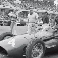 Italian GP Monza September 11, 1955 A smiling Eugenio Castellotti and mechanics walk the Ferrari 555 Squalo (555-4) to his 4th-place grid position as the omnipresent and camera-bedecked Bernard Cahier approaches. The Italian finished an impressive 3rd after the Moss Mercedes Benz W196 streamliner expired, better than the rest and all of them powerless in the face of Mercedes Benz superiority.
