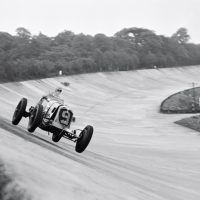 JCC 200 Brooklands August 27, 1938 In 1938 Britain, obsolete GP Maseratis, Alfa Romeos, and Bugattis were good enough to win or finish in the top three in most domestic races, their main opposition being the 1.5- and 2-liter ERAs and voiturette class Maseratis. These once-great cars were both obsolete and beginning to wilt, especially given the type of punishment you can see inflicted here. Bira, with engine cover flapping open, goes airborne around the Members’ banking in the White Mouse Garage’s Maserati 8CM (3011) to finish second behind Johnny Wakefield’s ERA, in a race he would have won but for fading brakes.