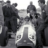 Dan Gurney in Lotus-Ford No. 93, testing at Indianapolis Motor Speedway. Looking on are Jim Clark, Colin Chapman, and Ford Special Vehicles executives. Gurney qualified to start in twelfth position at 149.019 miles per hour. He finished seventh. Ford Motor Company