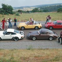The 1977 model year 911 lineup posed on a Weissach test track curve for a photo. From left, a Turbo 3.0 coupe, a 911S Targa, a Carrera 3.0 coupe, and a base 2.7 coupe. Porsche Archiv