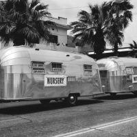 Wally Byam was a good showman and had a great sense of humor. Here he combined both by showing off two Airstream trailers at once- the larger ‘Nursery” and smaller “Mother-in-Law” apartment. Notice the signs in the windows that point out some of the best features of the sturdy Airstreams.