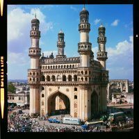 We can spot Andy Charles’ Ford pick-up and Airstream trailer parked in front of a fabulous building, which is the Charminar (sometimes spelled Char Minar) a monument and mosque built in 1591 Hyderabad, Telegana, India. Charminar means Four Towers in the Urdu language.
