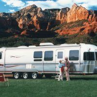 The most luxurious Airstream, the Limited, even came with folding chairs bearing the Limited name. This older couple look very happy as they camp in a lovely spot in view of a majestic range of mountains.