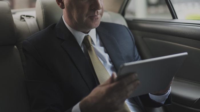 Man in car with tablet