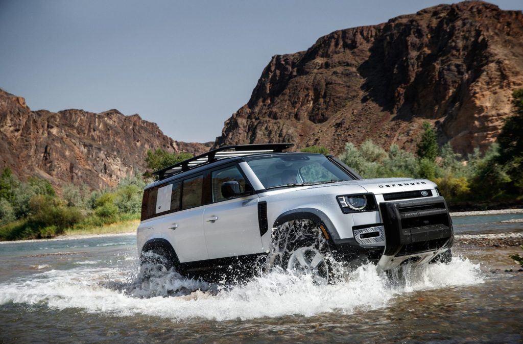 2020 Land Rover Defender driving through water.