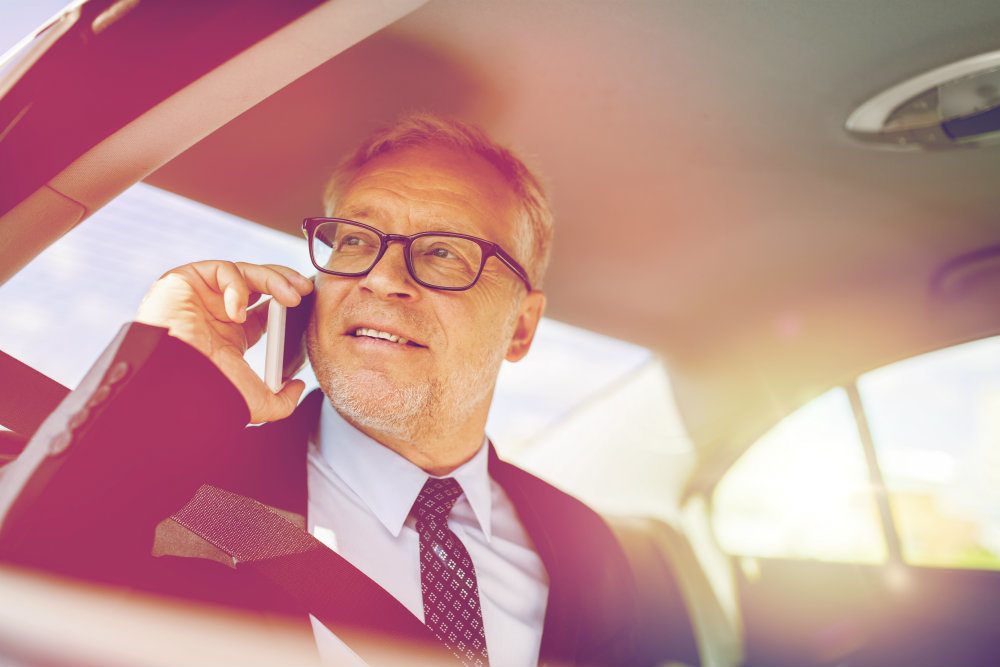 senior businessman calling on smartphone in car PZTGPE8