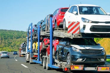 Montway Auto Transport reviews mention car carriers like this auto trailer traveling down the highway with several cars in tow.