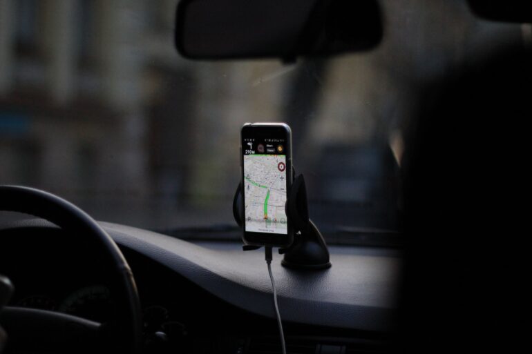 A smartphone in a car displaying a GPS navigation map that could collect telematics data.