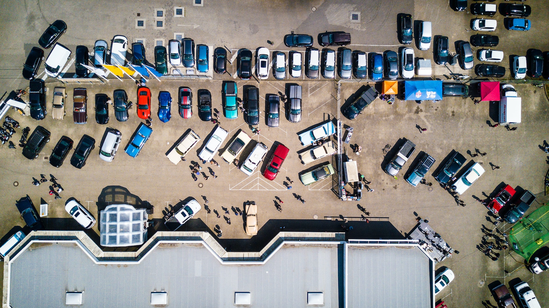 an aerial shot of a dealership with vehicles parked outside where falling used car prices have impacted the market