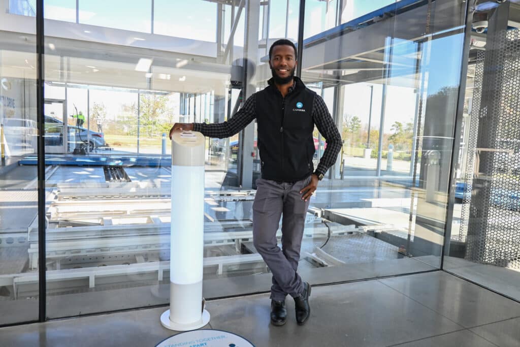 Carvell Copeland, Market Operations Manager for Carvana, standing in front of one of the company's car vending machines.