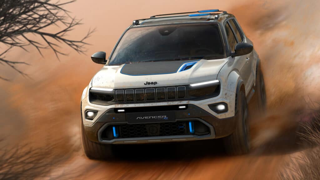 a jeep ev avenger drives through desert terrain kicking up dust