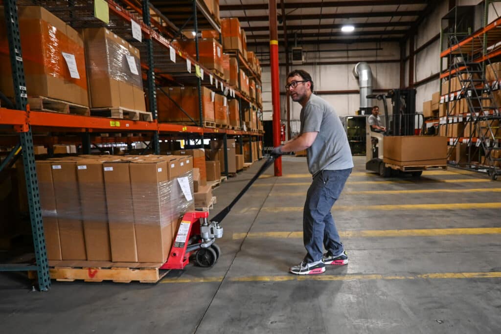 a strutmasters employee moves some packages ready to be shipped