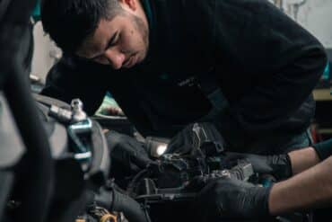 a repair technician works on the engine of a car