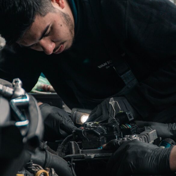 a repair technician works on the engine of a car
