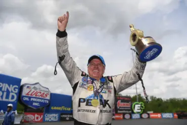 john force holding a trophy to celebrate a win