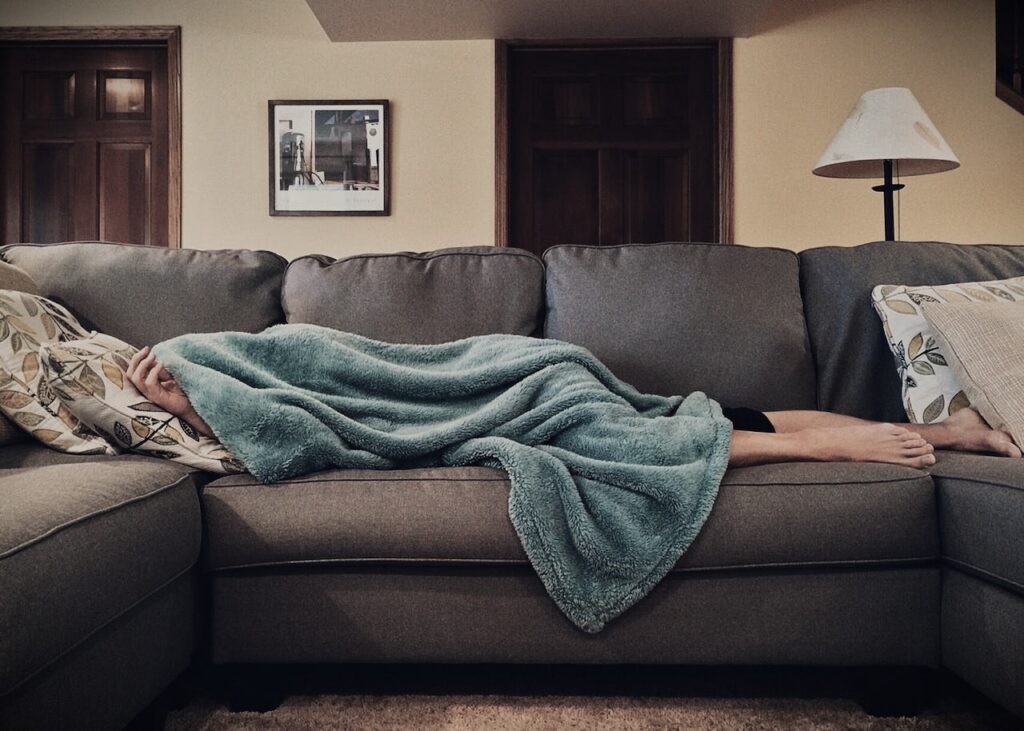 a person napping on the couch after a thanksgiving turkey dinner